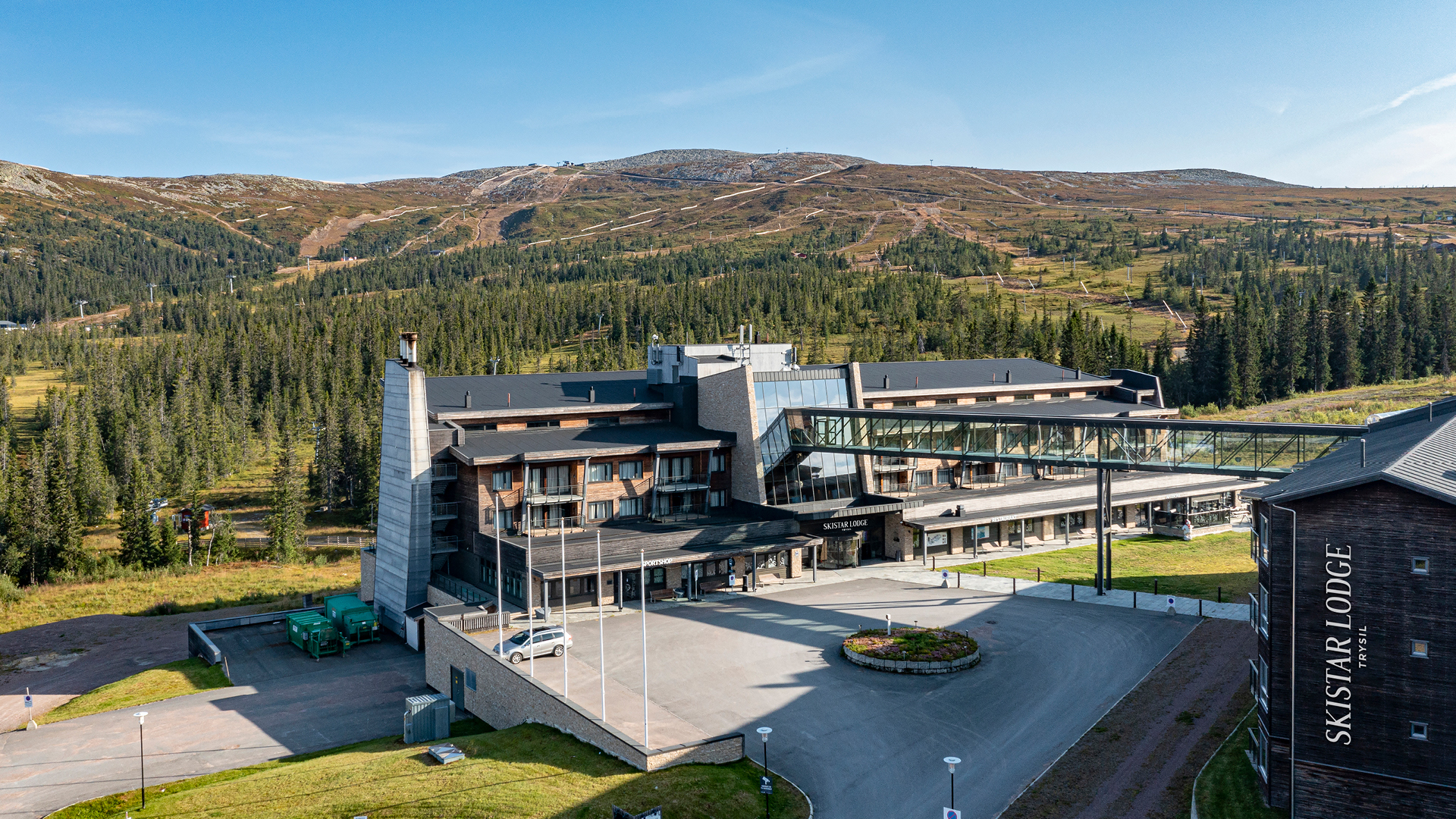 Hotellbyggnad i fjällmiljö vid SkiStar Lodge, omgiven av skog och berg i Trysil, Norge
