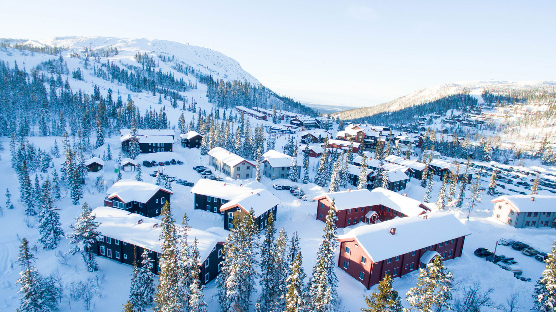Winter landscape in the ski resort of Åre, Sweden, with snow-covered trees and traditional buildings in sunny weather