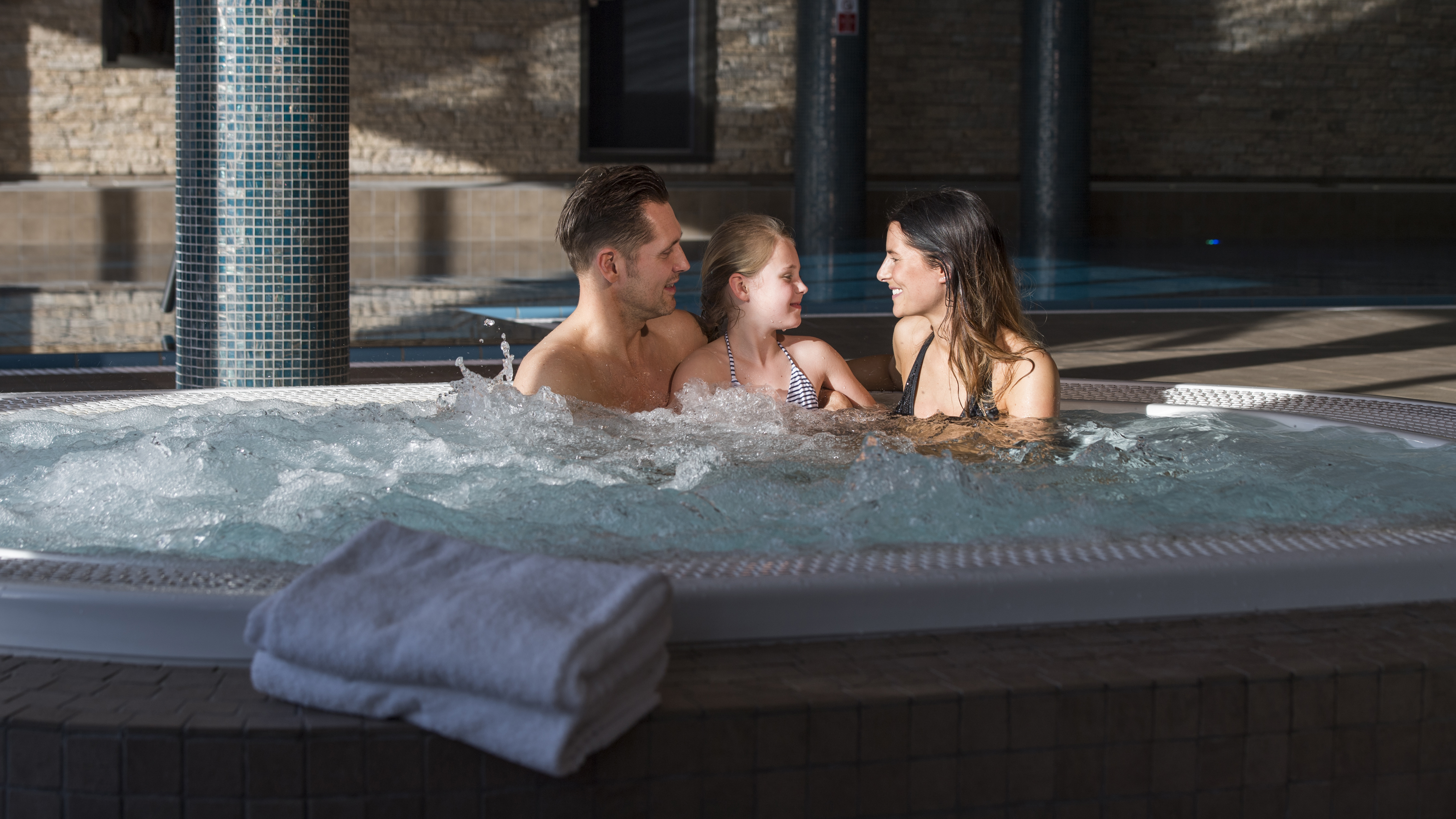 Familj njuter av tid i en bubbelpool på ett spa