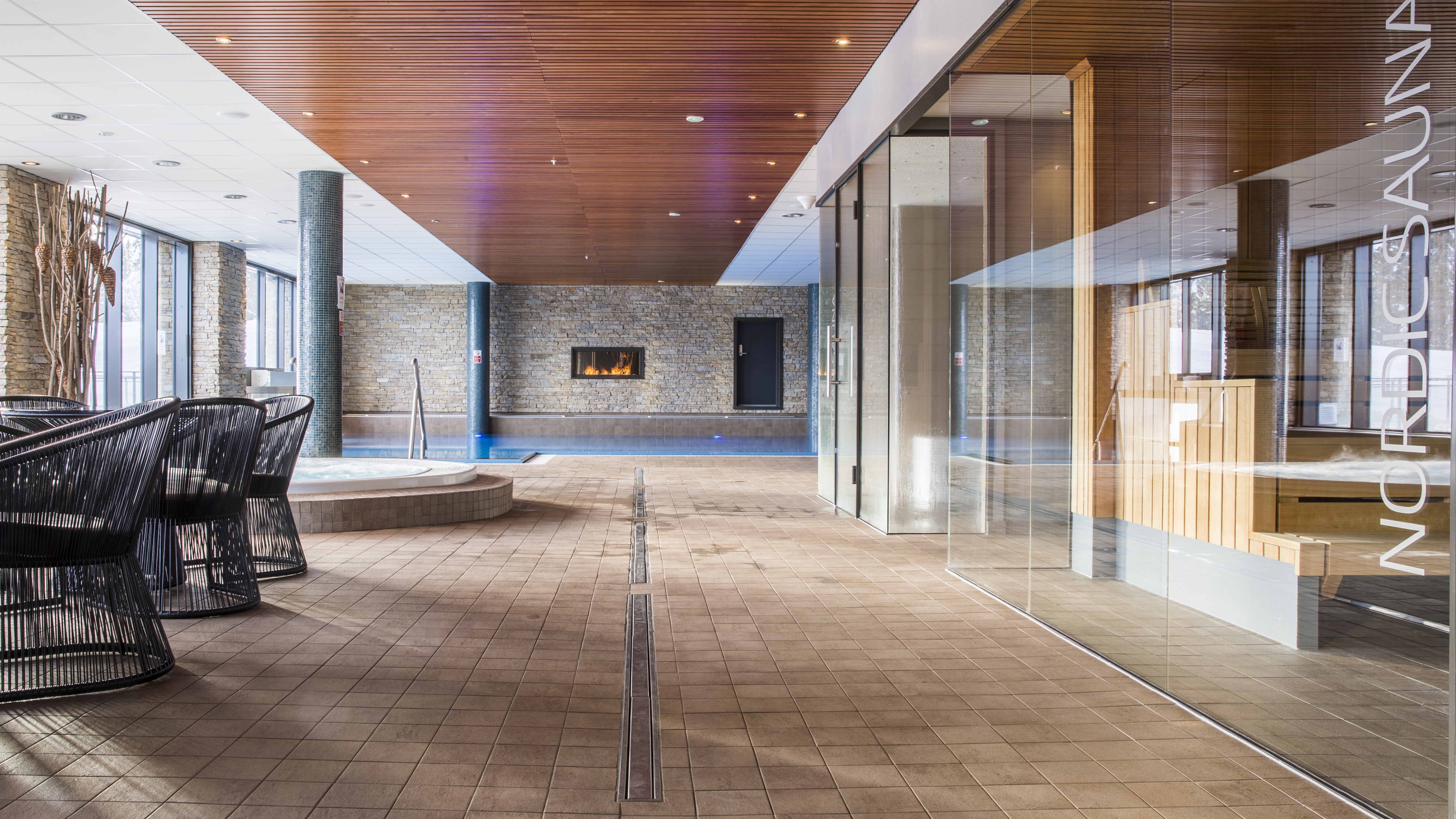 Inomhus spa med pool, bastu och eldstad i modern miljö