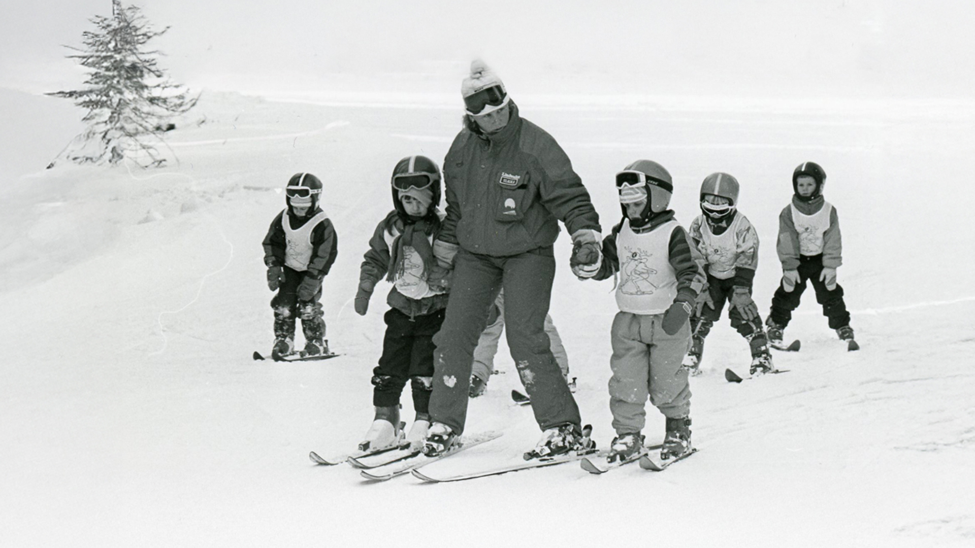 Skidinstruktör lär barn att åka skidor i snötäckt landskap