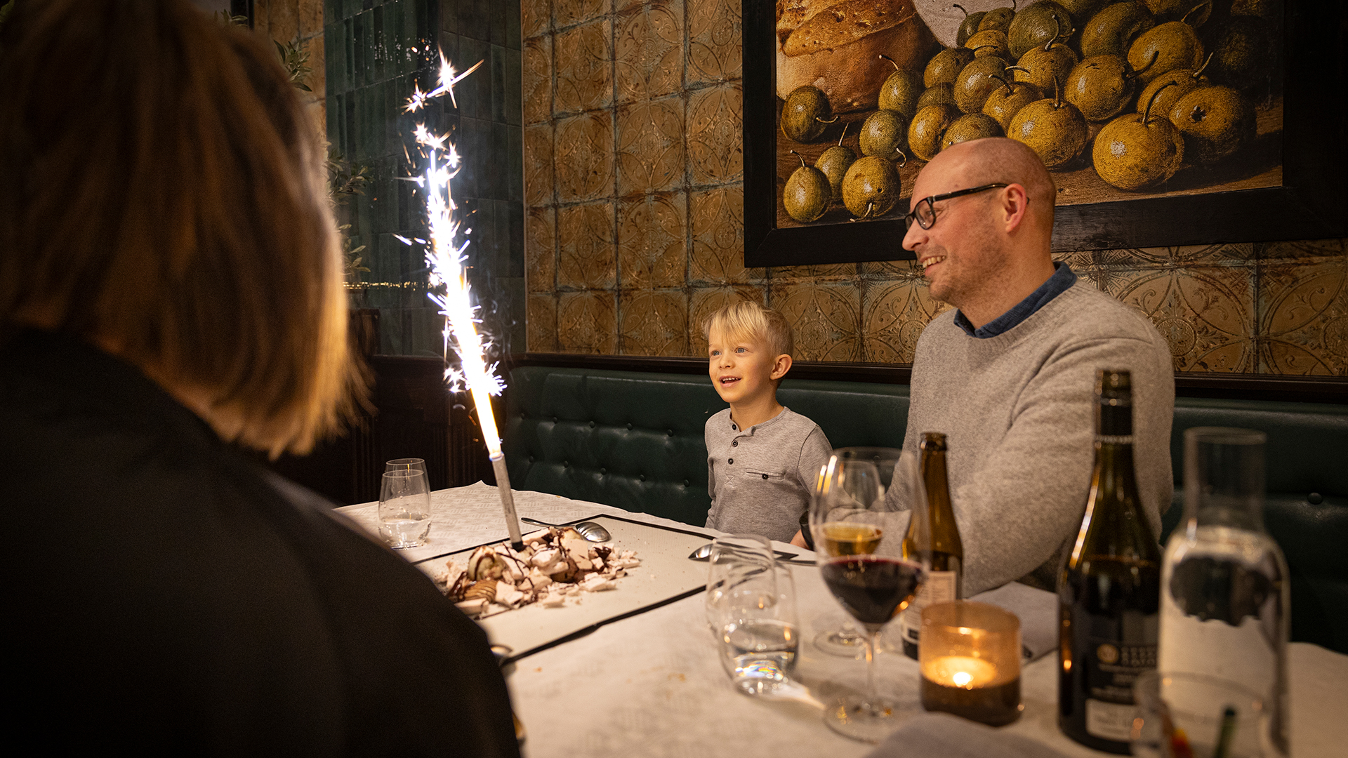 Far och son firar med glittrande tårta på restaurang