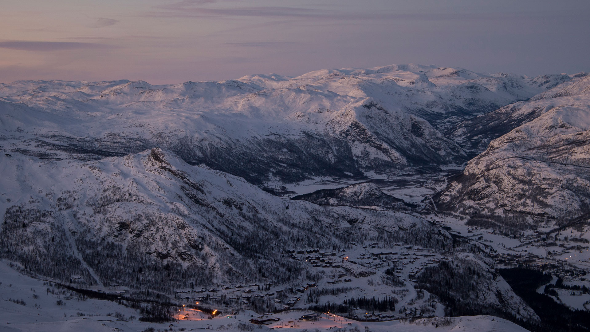 Winter landscape in the Norwegian mountains at dusk, with snow-covered mountains and valleys