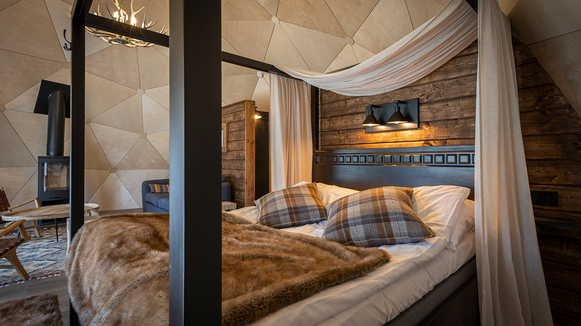 Lyxigt hotellrum med himmelssäng, mjuka kuddar och en mysig braskamin, träpaneler på väggarna och elegant belysning