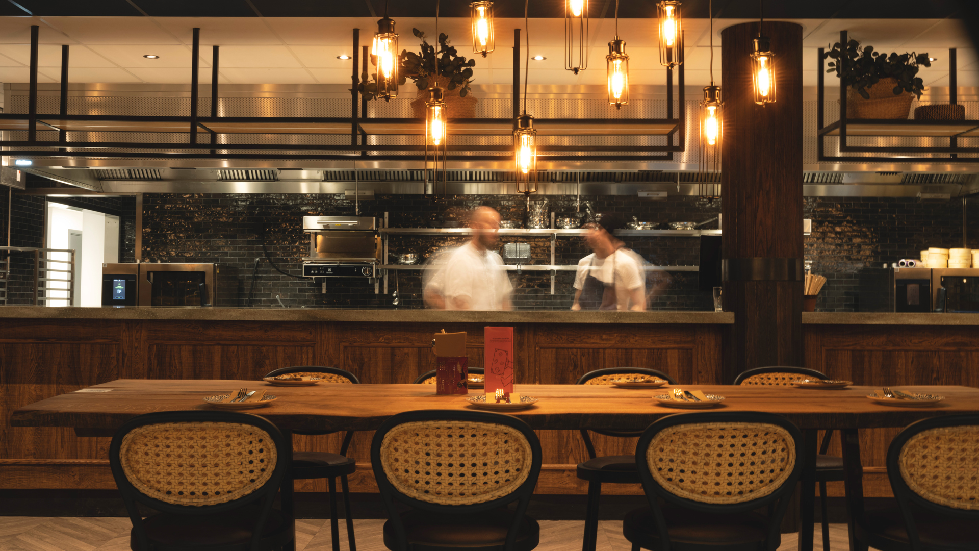 Restauranginteriör med öppet kök och elegant belysning i varm atmosfär