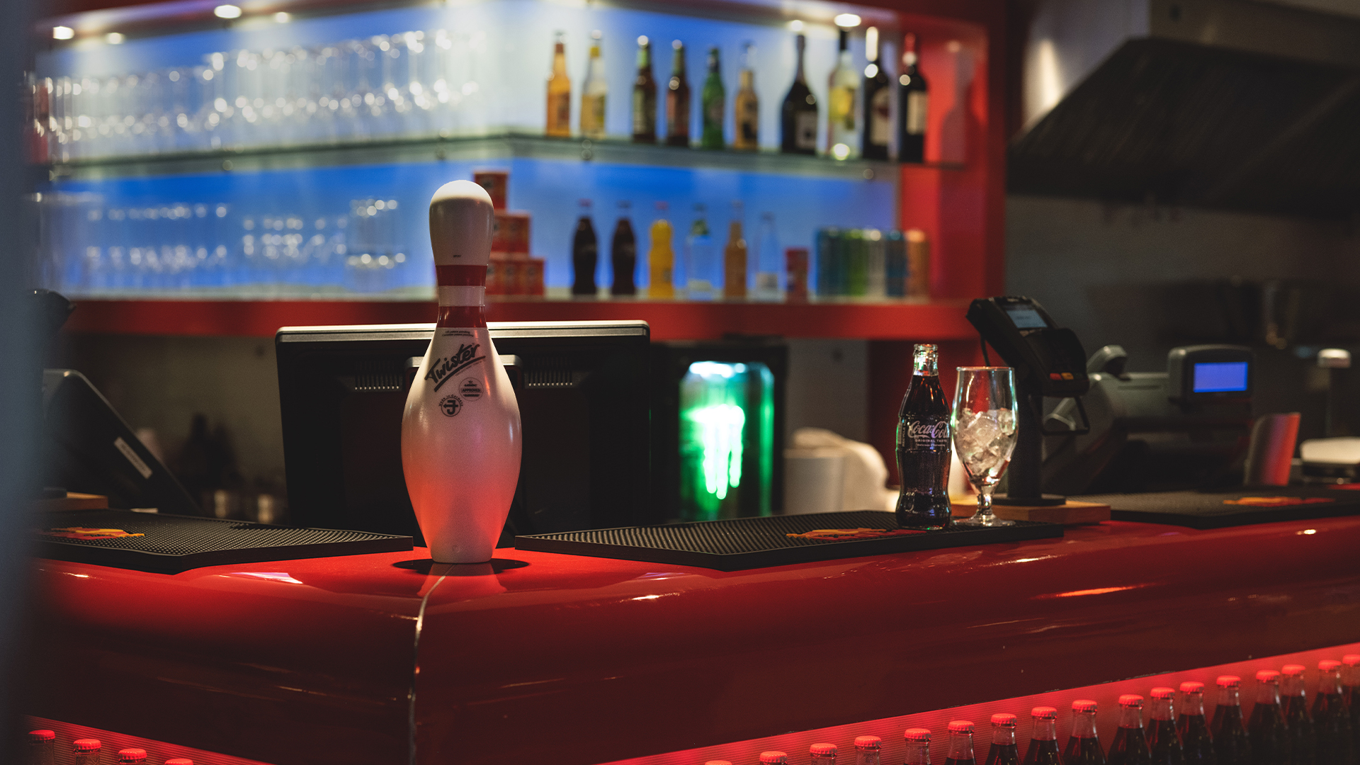 Moderne bowlingtema: En bowlingkjegle står på en stilren bardisk med drikker og glass, omgitt av en hylle fylt med flasker og glass