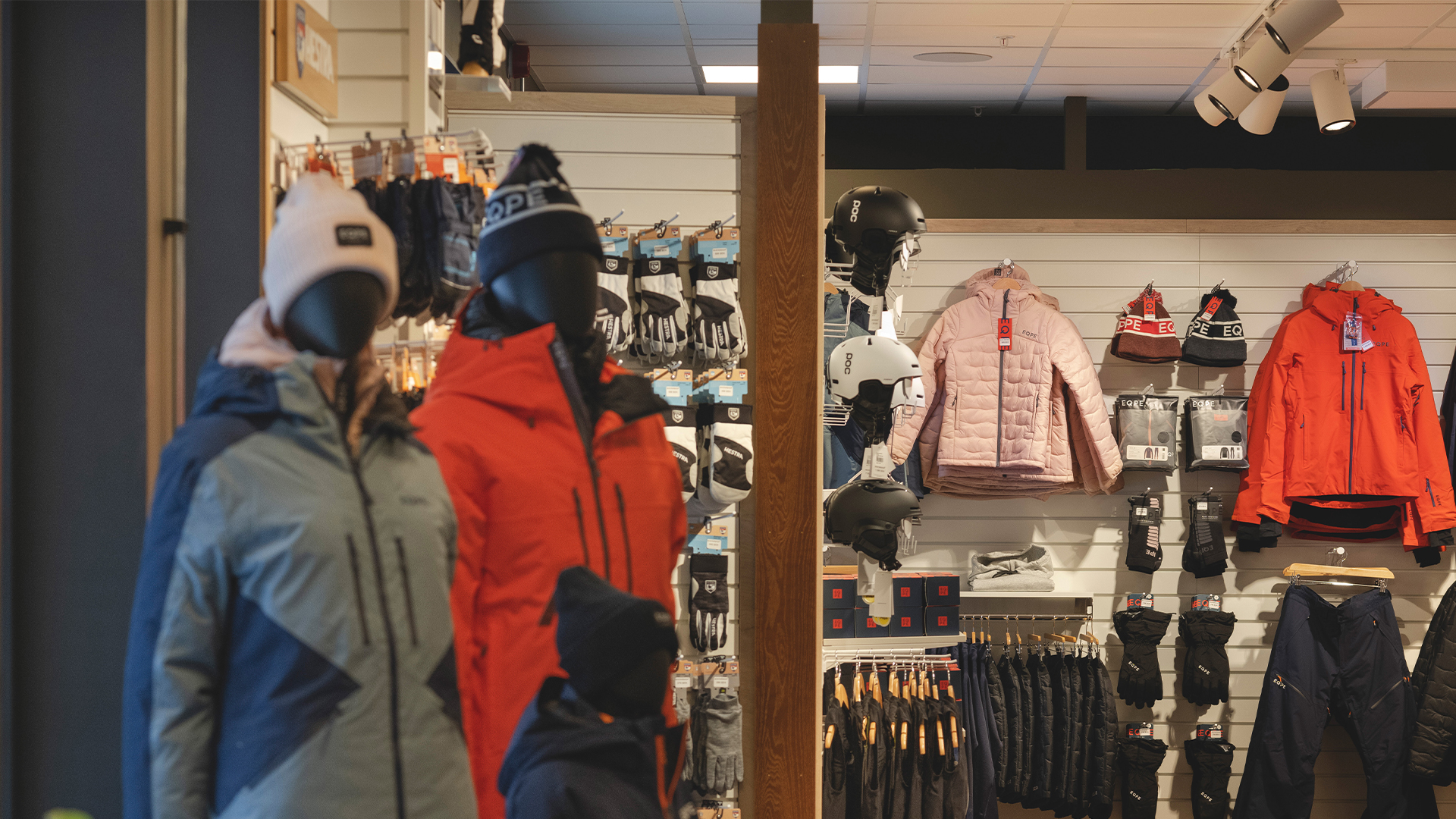 Butik med vinterkläder, inklusive jackor, mössor och handskar på skyltdockor och väggställningar