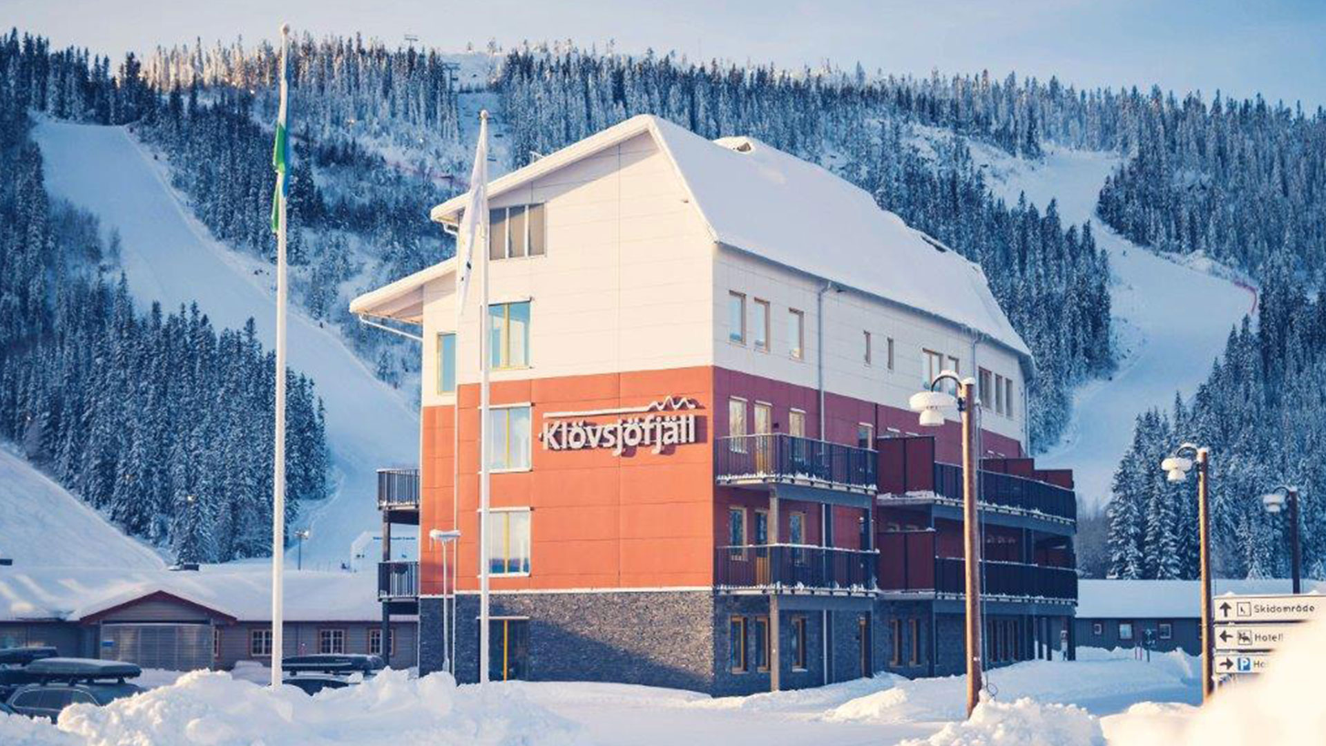 Hotell Klövsjöfjäll med snötäckta berg och skidbackar i bakgrunden