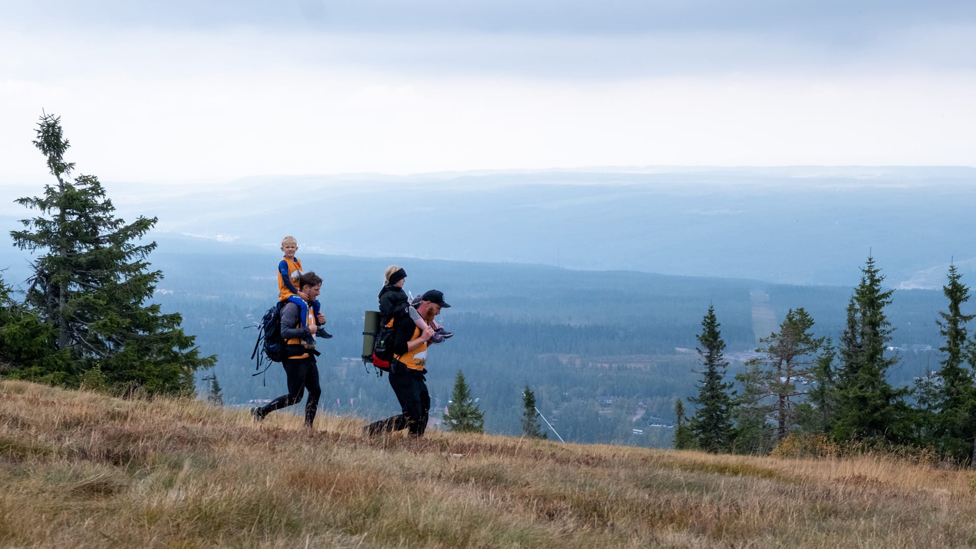 Familj vandrar på fjällstig i Sverige, barn i bärstol