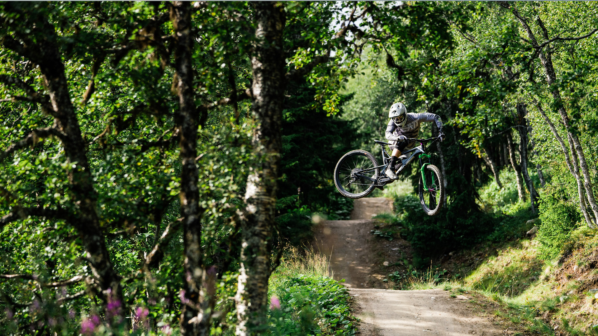 Mountainbike-cyklist utför hopp i skogig terräng