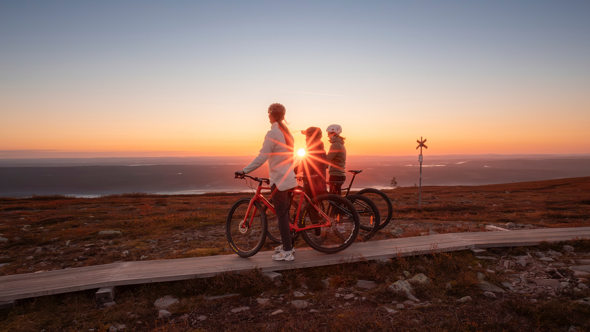 Cykling på en spång vid solnedgång med utsikt över fjället